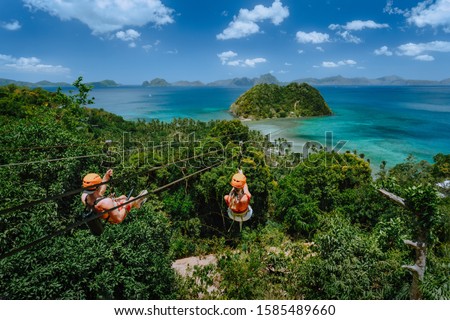 Zipline over Las Cabanas Beach with tourist on sunny day with white clouds over sea. El Nido, Palawan, Philippines Royalty-Free Stock Photo #1585489660