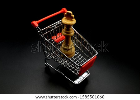 chess pieces and  shopping cart on black background