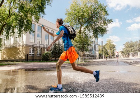 male runner running street and take selfie on phone in summer day