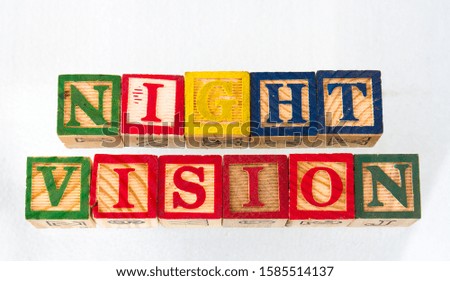 The term night vision visually displayed on a white background using toy blocks image with copy space