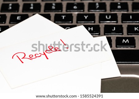 Writing on white label Recycle. Text with Recycle on paper. Label on keyboard.