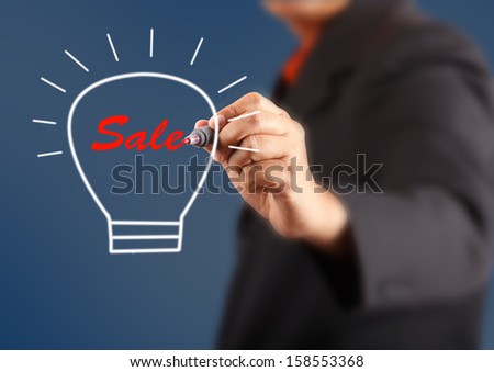 businessman hand with a pen drawing light bulb inside is sale