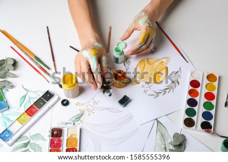 Artist painting picture at table