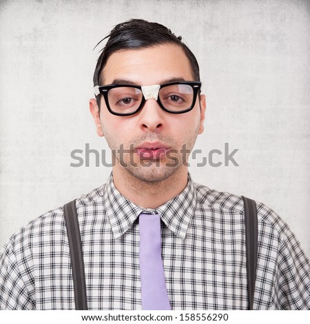 Portrait of young nerd with eyeglasses isolated on grunge background. 