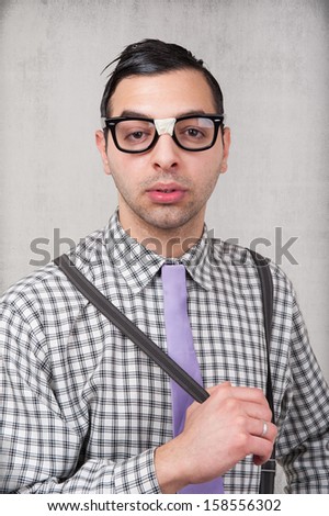 Portrait of young nerd with eyeglasses isolated on grunge background. 