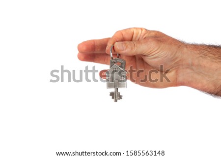 Man's hand giving a new metal key with home shaped keychain, isolated. New home concept
