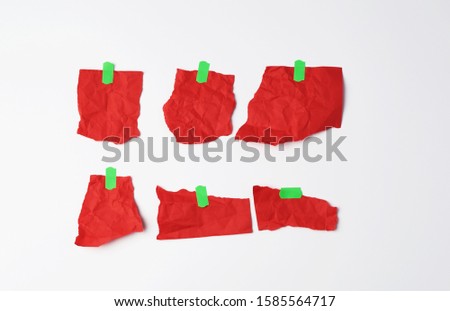 various empty red pieces of paper stuck with green velcro on a white background, place for text