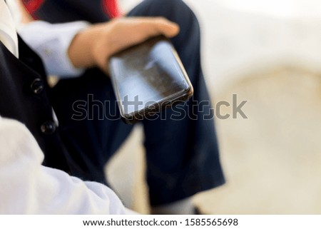 Young boy play online games on a smartphone. Beautiful teenager use phone from side