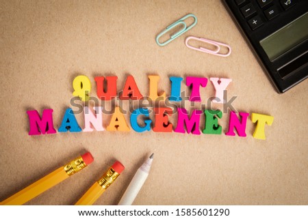 Quality Management. Audit, monitoring and service concept. Text from colorful wooden letters on cardboard background
