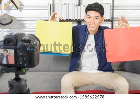 Young Happy Asian male sharing content on live streaming make video broadcast with internet subscribers. An Influencer marketing concept with will fun vlogging live on social media networks.