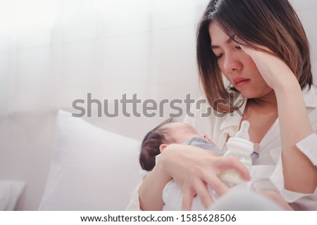 Tired Mother Suffering from experiencing postnatal depression.Health care single mom motherhood stressful. Royalty-Free Stock Photo #1585628506