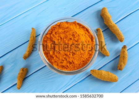 Turmeric on bowl Isolated in blue