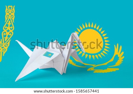 Kazakhstan flag depicted on paper origami crane wing. Handmade arts concept