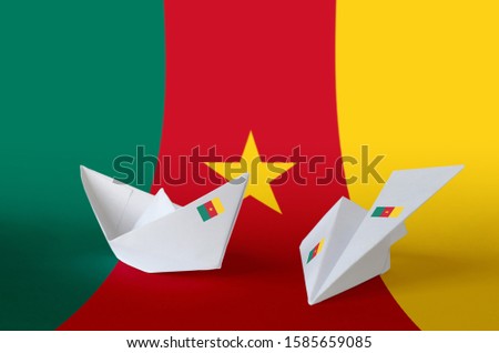 Cameroon flag depicted on paper origami airplane and boat. Handmade arts concept