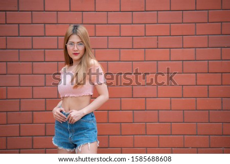 Portrait of beautiful asian chic girl wear black dress pose for take a picture on brick wall,Lifestyle of teen thailand people,Modern woman happy concept,Korea style