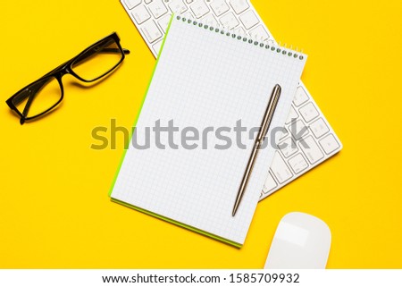 Top view of business working place with cup of coffee, Empty workspace on yellow table background.