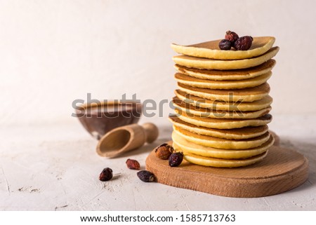 Fresh sweet pancakes with chocolate jam, cinnamon sticks and marshmallows on a gray background with place for your text.