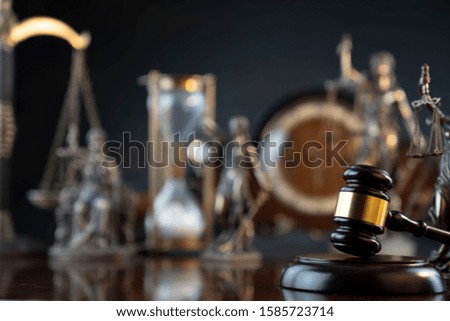 Legal office concept. Mallet of the judge, statue of justice, hourglass, vintage clock, scales. Gray bokeh background.