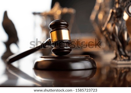 Legal office concept. Mallet of the judge, statue of justice, hourglass, vintage clock, scales. Gray bokeh background.