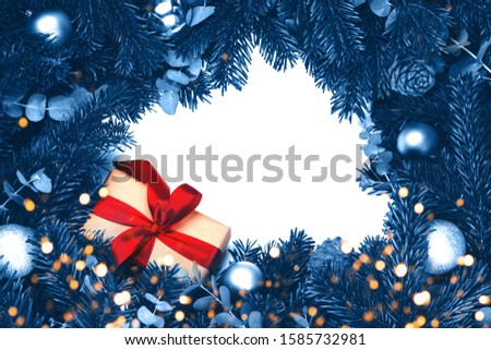 Branches of the pine tree with present on the white background. Trendy blue winter color concept.