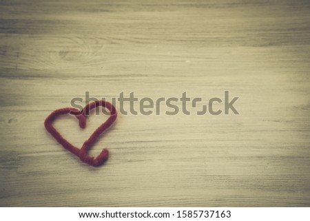 Heart made of red material on a wooden surface. Valentine's day card with place for text. Top view. Place for text.