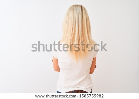 Middle age woman wearing casual t-shirt standing over isolated white background standing backwards looking away with crossed arms