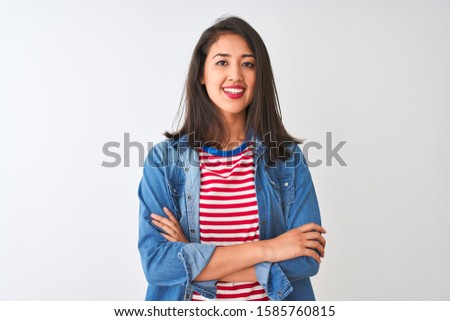 Young chinese woman wearing striped t-shirt and denim shirt over isolated white background happy face smiling with crossed arms looking at the camera. Positive person.