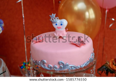 pink cake with a toy tooth