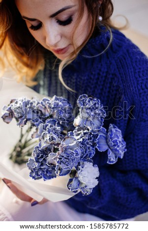 Image of cute woman with blue bouquet.