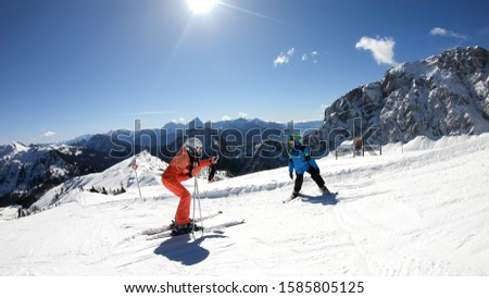 Active holiday winter alps.Mother taking pictures of her son while skiing. Beautiful mountain panoramas.