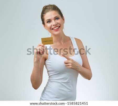 happy woman in white casual vest holding credit card in front of and pointing finger. isolated female portrait.