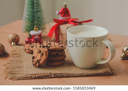 Milk with Chocolate cookies and Gift box on wood table. Christmas.