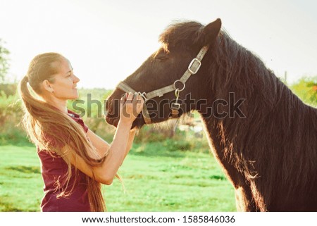 young beautiful girl stroking a horse on a Sunny day in the open vozduhonosnye