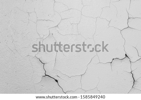 Cracked flaking white paint on the wall, background texture Royalty-Free Stock Photo #1585849240