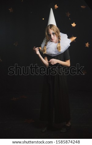 sad circus artist, clown girl in black and white outfit with a cap on her head