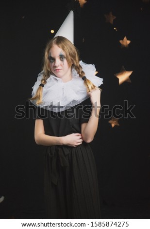 

sad circus artist, clown girl in black and white outfit with a cap on her head