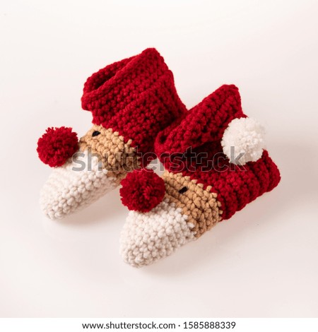 pair of handmade knitted white-red socks. Ideal for present for cold winter days for small children. Picture taken on a white background.