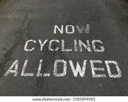 Now Cycling allowed sign painted on road.