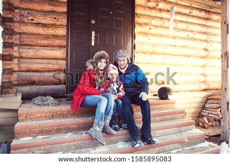 winter portrait of a family in the winter outdoors near a house