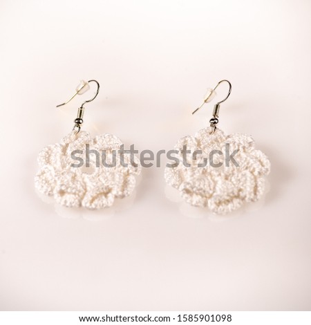 Pair of handmade knitted shiny white ear-rings. Ideal for Christmas present. Picture taken on a white background, and ready for use.