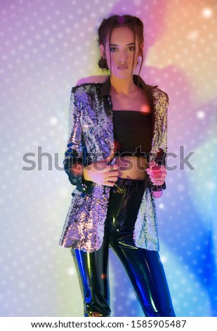 Party poster ready concept, beautiful model dancing in colorful lights , smiling, wearing shiny sequins outfits, with festive braid hairstyle