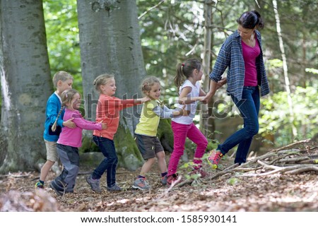 Kindergarten teacher playing with kids in a wood kindergarten Royalty-Free Stock Photo #1585930141