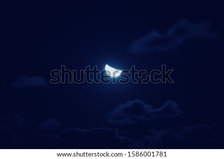 Half of bright moon among dark clouds in night sky with motion blur. Moon gathering concept