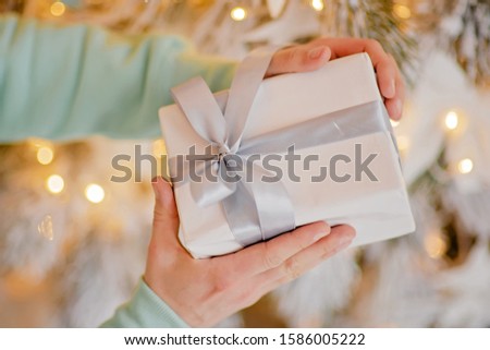 Adult man holds in his hand a box with a gift for Advent holiday. Happy New Year and Merry Christmas