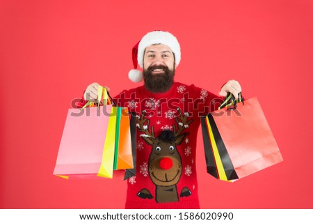 Keep calm and carry on. Bearded man hold shopping bags. Happy hipster carry paper bags. Holiday purchases in colorful bags. Winter sale and discount. Christmas and New Year preparation. Grab bags.