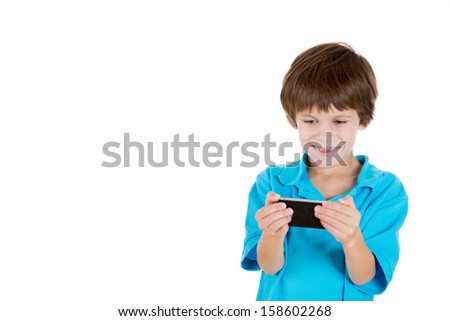 Closeup portrait of adorable boy holding cell phone in hands and happy by what he sees isolated on white background with copy space