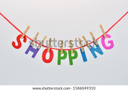 
The word Shopping, made with wooden letters, hung on a rope with clothespins