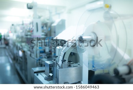 Machines for packing products Within the factory, sterile beauty industry in order to maintain maximum cleanliness.shallow focus effect. Royalty-Free Stock Photo #1586049463