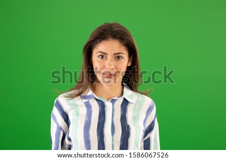 Pretty Caucasian girl on summer day smiling at camera greenscreen. Casual portrait of attractive woman in striped top posing on green screen
