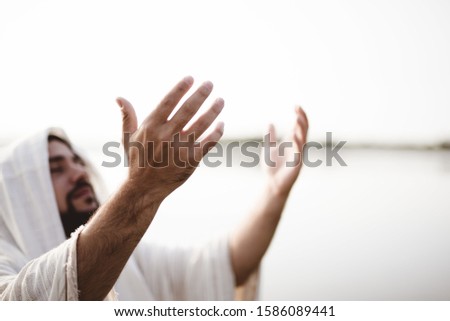 A closeup shot of the Jesus Christ hand towards the sky with a blurred background